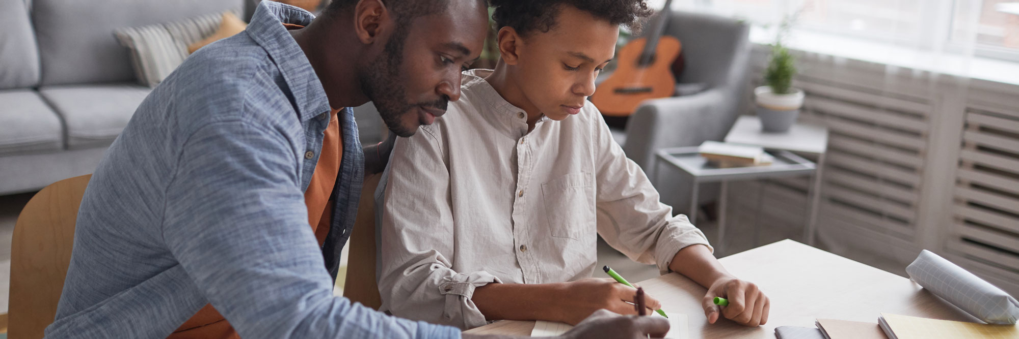 close up of a father helping his child with paperwork